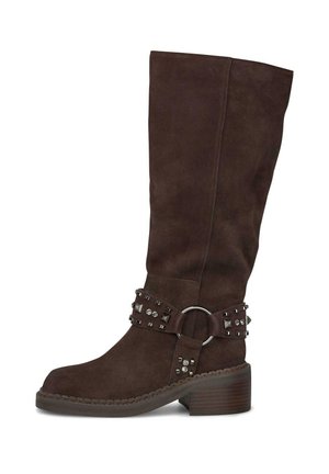 Bota de ante marrón hasta la rodilla con un tacón grueso, que presenta acentos de tachuelas y un anillo metálico en la correa ajustable alrededor del tobillo.