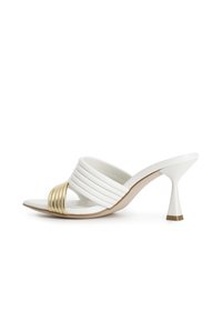 Sandalia blanca de tacón curvado, con un empeine a rayas y una banda dorada en la parte frontal. Acabado suave y diseño aerodinámico.