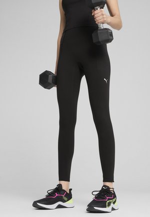 Colanți sport negri, cu o ajustare strânsă, textură netedă, împodobiți cu un mic logo alb Puma pe lateral, asortați cu adidași negri și roz.