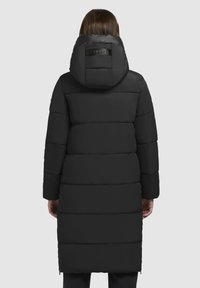 Giacca a vento nera imbottita con cappuccio, caratterizzata da un design trapuntato, hardware lucido al collo e un taglio fino al ginocchio.