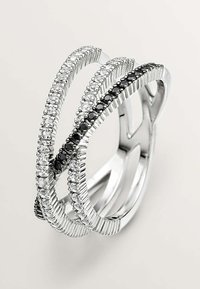 Anillo de plata con bandas entrelazadas, decorado con piedras claras y negras en una textura acanalada. Diseño elegante con un toque moderno.