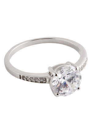 Silberner Ring mit großem rundem klarem Edelstein in einer Vier-Krappen-Fassung und kleinen Steinen, die entlang eines Teils des Rings eingelassen sind.