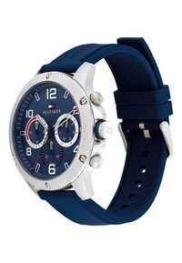 Reloj cronógrafo de color azul marino con un bisel texturizado plateado, acentos blancos y una correa de goma. Presenta marcadores de hora en negrita y tres subesferas.