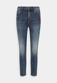 Vaqueros de mezclilla azul oscuro con un corte ajustado, que presentan un ligero desgaste y un diseño bordado en rojo en el bolsillo delantero.