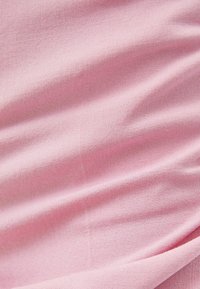 Light pink, textured fabric with a soft surface, displaying subtle creases and a smooth drape. Suitable for clothing or upholstery.