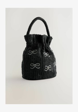 Sort perleposeret håndtaske med en bølgende top, prydet med sølvfarvede bue-dekorationer og et rundt håndtag. Struktureret form med en tekstureret overflade.