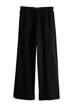 Czarne spodnie o szerokich nogawkach z elastycznym pasem i troczkami, wykonane z teksturowanej tkaniny.