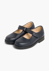 Zapatos Mary Jane de cuero azul marino con puntera redonda, detalles de borde ondulado y una correa sobre el empeine, con suela plana de goma.
