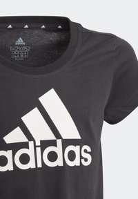 Camiseta negra de Adidas para niños de 11 a 12 años, con un gran logo blanco de Adidas en el pecho y cuello redondo.