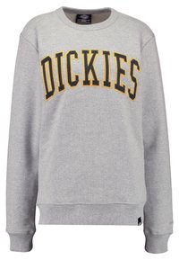 Sweat-shirt gris à col rond avec "DICKIES" imprimé en lettres noires et jaunes en gras. Comprend des poignets et un ourlet côtelés, fabriqué en matériau doux.