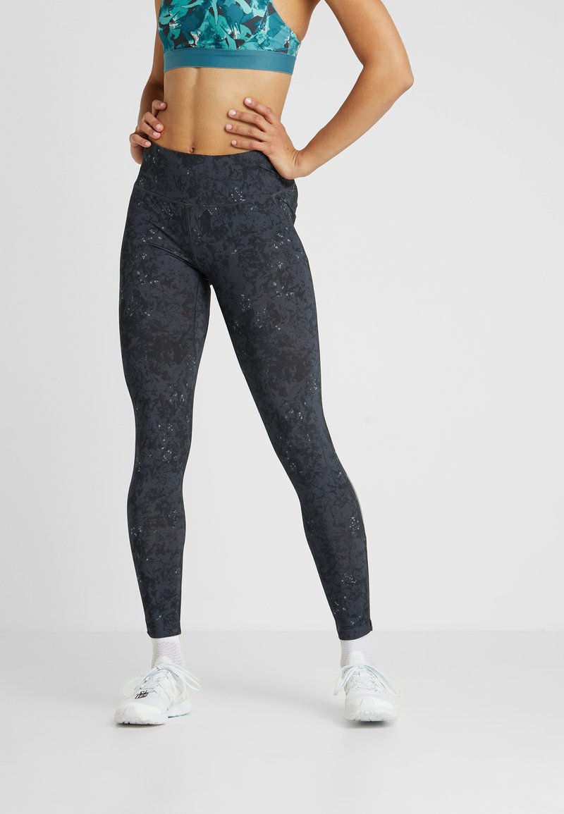 Svarta leggings med en texturerad blommönster, hög midja och slim fit, kombinerat med en teal sport-bh.