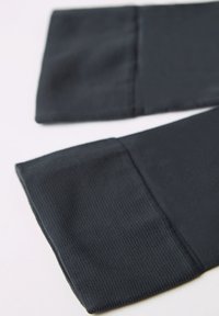 Mørkeblå ærmer lavet af tekstureret, åndbart stof med en glat afslutning i kanten. Har et klart, enkelt design med syede kanter.