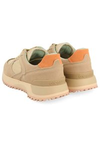 Chaussures en daim beige avec une finition texturée, présentant un accent de talon en daim orange et une semelle en caoutchouc rose clair avec des crans.
