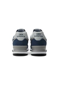 Mörkblå New Balance sneakers med övre del i mocka och läder, med en grå hälkappa, vit logotyp och grå sula med svarta accenter.