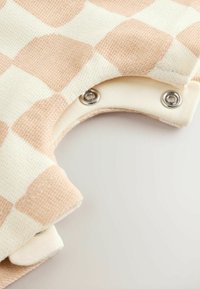 Katoenen kledingstuk in een roze geruit patroon met off-white accenten. Voorzien van drukknoopsluitingen en een gestructureerde stof.
