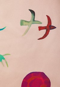 Látka se světle růžovým pozadím obsahuje barevné abstraktní tvary: tyrkysové ptáky, zelené akcenty a velký vícebarevný kruhový vzor.