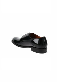 Chaussure en cuir verni noir avec un bout rond, surface lisse, devant lacé et un talon bas. Présente une finition lisse et brillante.