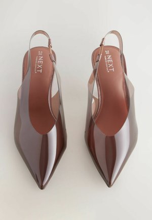 Slingback schoenen van glanzend bordeauxrood plastic met een puntige neus en uitsnijdingen aan de zijkanten. Platte hak voor comfort.