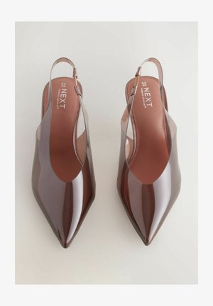 Slingback schoenen van glanzend bordeauxrood plastic met een puntige neus en uitsnijdingen aan de zijkanten. Platte hak voor comfort.