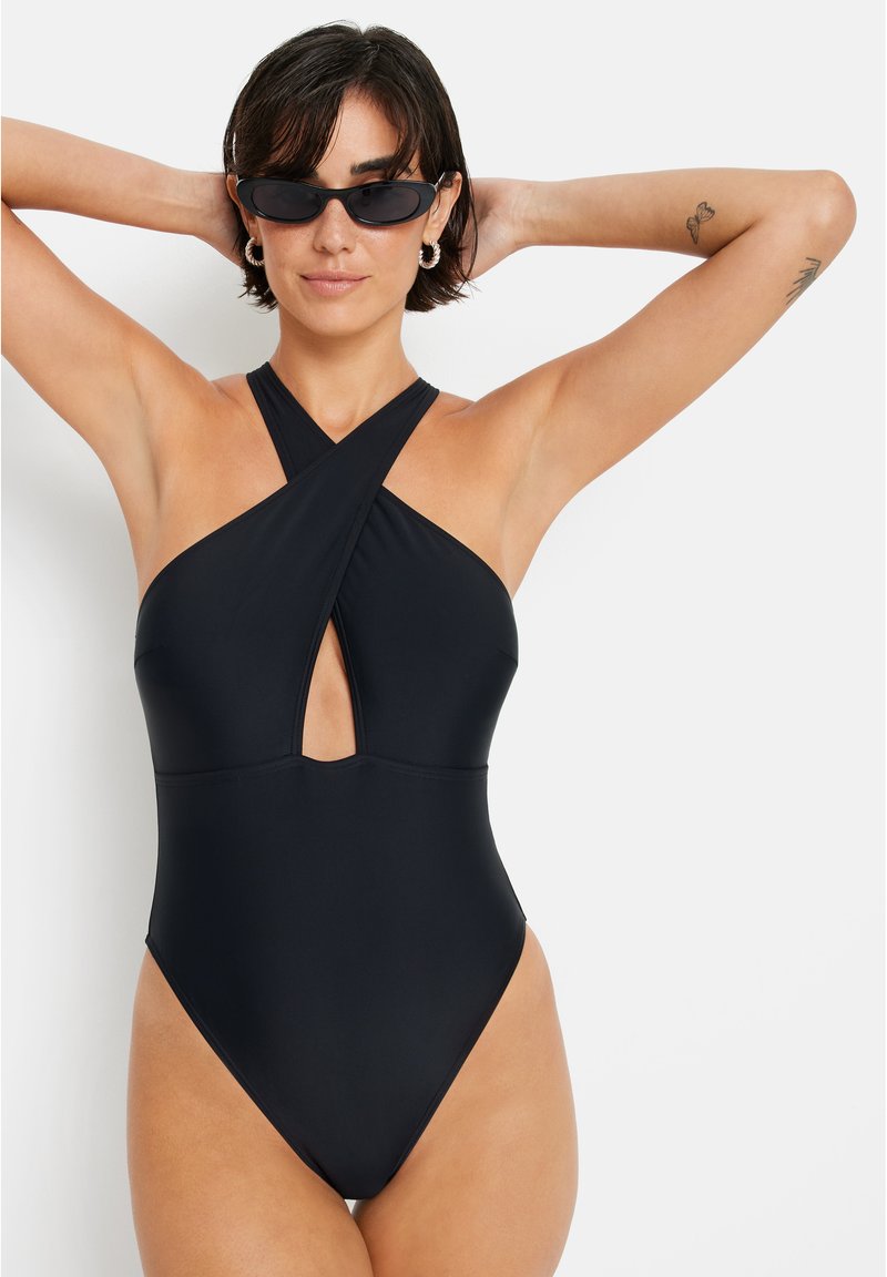 Fato de banho integral preto com decote halter em design cruzado e detalhe recortado na parte da frente, feito de um tecido liso e elástico.