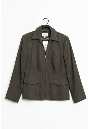 Veste zippée vert foncé avec col et deux poches avant à rabat, suspendue sur un cintre noir sur fond blanc.