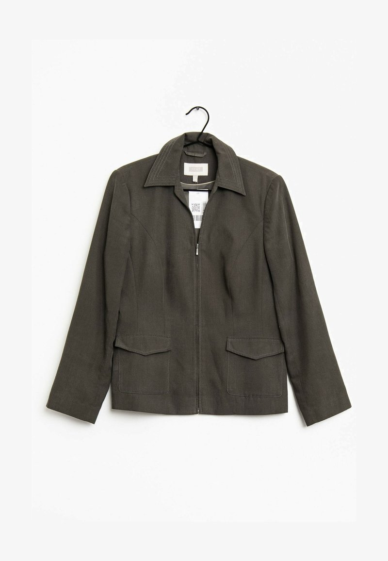 Veste zippée vert foncé avec col et deux poches avant à rabat, suspendue sur un cintre noir sur fond blanc.