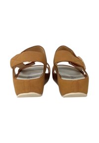 Sandali platform in suede marrone con una fascia larga, apertura sul retro e rivestimento interno testurizzato. Presentano una suola in gomma bianca per una migliore aderenza.