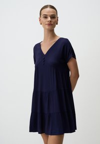 Marineblaues, kurzärmeliges Kleid mit V-Ausschnitt, drei Knöpfen an der Vorderseite und gestuftem Rüschendesign; glatte Textur und leichtes Material.