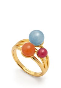 Goldfarbener Ring mit drei runden Edelsteinen: einem hellblauen, einem orangefarbenen und einem pinkfarbenen Stein, auf geschwungenen Bändern für ein schichtweises Design.