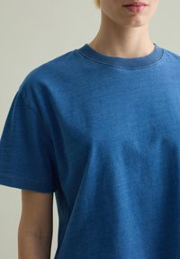 Blauwe katoenen t-shirt met een ronde hals, korte mouwen en een zachte textuur. Heeft een losse pasvorm en geen zichtbare patronen of accenten.
