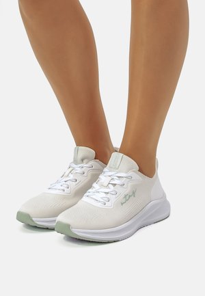 Zapatillas deportivas blancas con parte superior de malla texturizada, acentos verdes y cordones. Presentan un collar acolchado y una suela ligera.