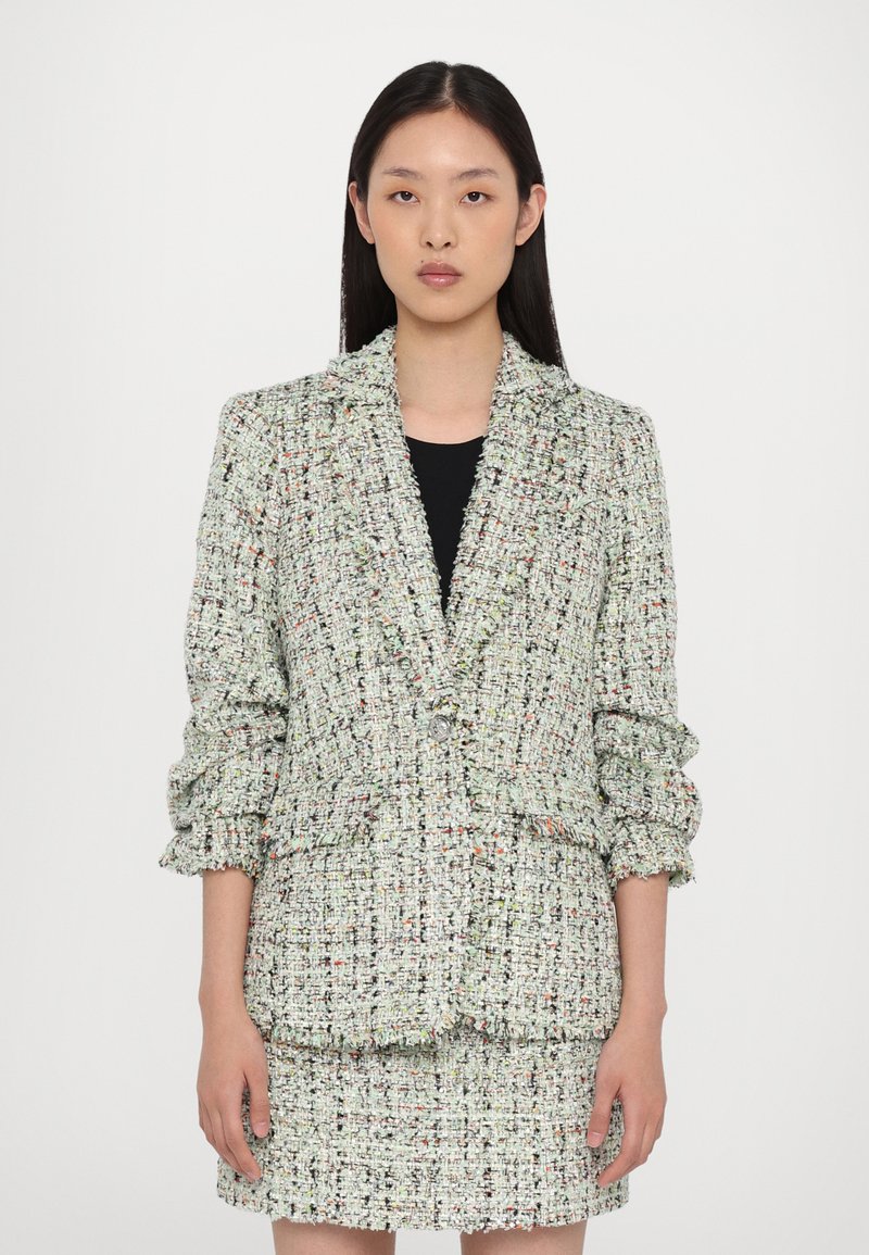 Texturierter Tweed-Blazer in grün und weiß mit mehrfarbigen EinsprenGlungen, geschlitzten Revers und leicht aufgeschlagenen Ärmeln, kombiniert mit einem passenden Rock.