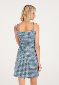 Ärmelloses blau bedrucktes Kleid mit tailliertem Oberteil, schwingendem Rock und dünnen Trägern. Leichter Stoff mit geometrischem Muster.