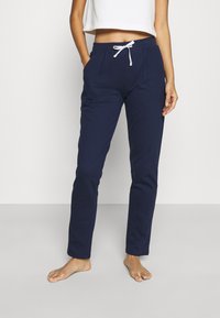 Navyblauwe joggingbroek met een strikceintuur, voorzien van twee zijzakken en een aansluitend ontwerp, gemaakt van zacht, rekbaar materiaal.