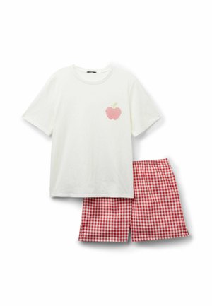 Weißes kurzärmeliges Hemd mit einer kleinen rosa Apfel-Grafik, kombiniert mit rot-weiß karierten Shorts.