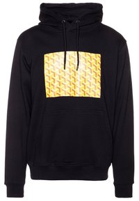 Black hoodie with a large yellow geometric pattern on the front. Features a drawstring hood and a front pocket. Soft fabric texture.