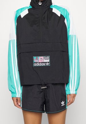 Sort Adidas vindjakke med turkis og hvide stribede ærmer, kombineret med matchende sorte Adidas shorts med logo på venstre ben.