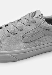Graue Wildledersneaker mit passenden Schnürsenkeln, runder Zehenpartie und Gummisohle. Verfügt über eine strukturierte Oberfläche und ein dezentes Logo auf der Zunge.