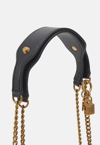 Musta nahkavyö olkahihna kultasävyisellä hardwarella, jossa on sileä pinta, ketjumaiset yksityiskohdat ja pieni, kaiverrettu salpalukko.