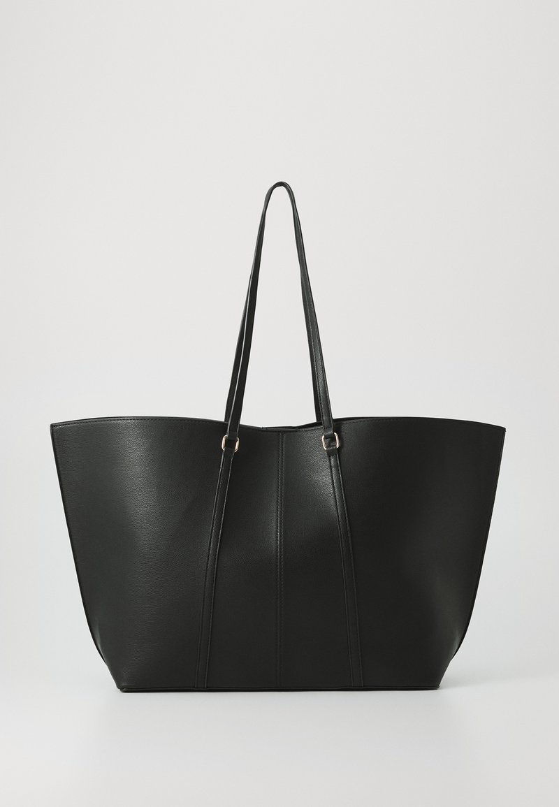Sac fourre-tout noir en cuir lisse, avec un large dessus ouvert et deux longues anses. Il présente des coutures verticales pour un détail supplémentaire.