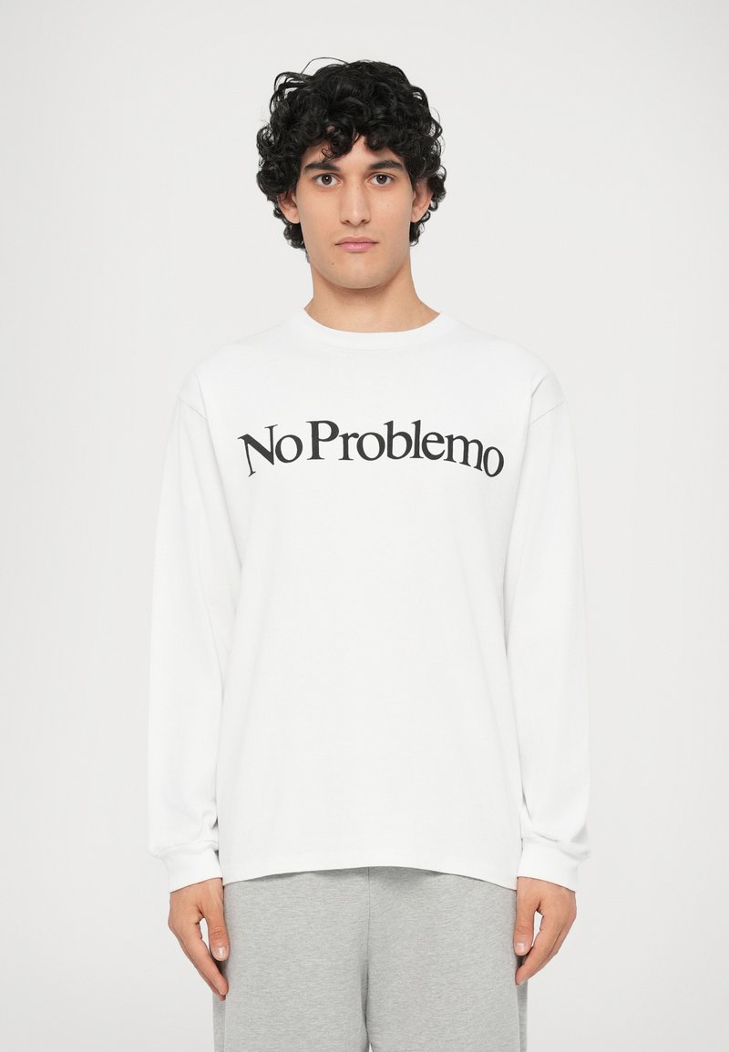 Pikend käsivartega valge särk, mille eest puusalt on must "No Problemo" graafika. Pehme kangas, lõdvestatud istuvus ja ümar kaelus.