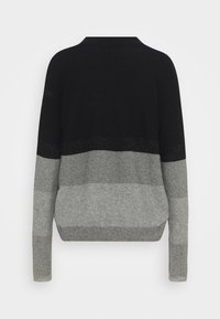 Svart och grå tröja med en blockfärgsdesign i olika nyanser, strukturerad stickning och en något lös passform. Bakvy visas.