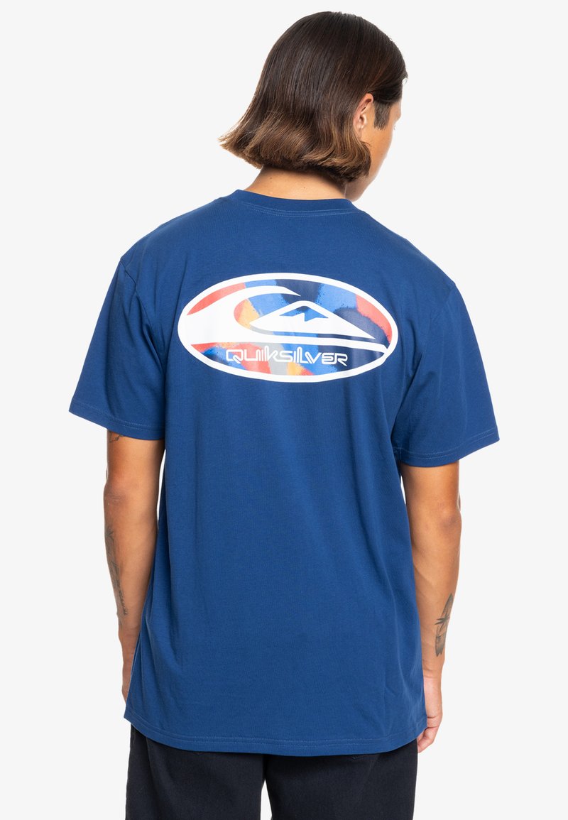 Navy blue cotton t-shirt featuring a large white and colorful Quiksilver logo on the back, regular fit with short sleeves.