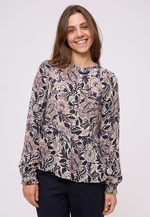 Blusa a maniche lunghe in navy e crema con un motivo floreale paisley, scollatura rotonda e dettagli con bottoni lungo il davanti. Tessuto morbido e testurizzato.