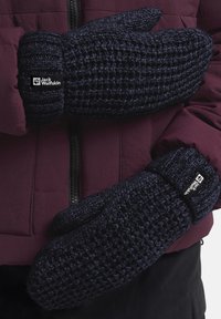 Marineblaue gestrickte Handschuhe mit gerippten Bündchen und Logoetikett, vor einem kastanienbraunen Jacken Hintergrund präsentiert. Texturiert und warm, mit Design für Handbedeckung.