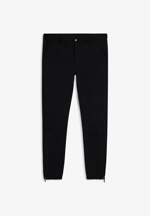 Pantaloni neri a sigaretta realizzati in materiale elasticizzato, con tasche laterali, zip alla caviglia e un logo discreto vicino alla vita.