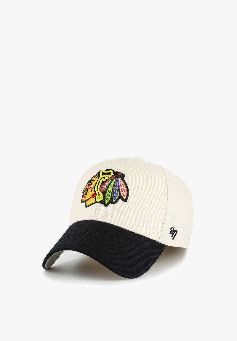 Gorra de béisbol blanca con visera negra, que presenta un colorido logo de cabeza de nativo americano y un pequeño emblema negro '47' en el costado.