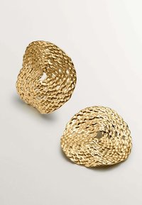 Cuencos de metal dorado con un diseño texturizado y tejido, presentando formas irregulares y patrones de calado, exhibidos sobre un fondo claro.