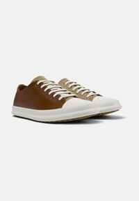 Zapatillas de cuero marrón y beige con cordones blancos, puntera redondeada y suela de goma beige. Textura suave con acentos de color contrastantes.