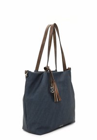 Navy blue canvas tote bag with brown leather straps and a decorative tassel. Features silver hardware and a minimal design.